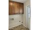 Clean laundry room with overhead cabinets and tile flooring at 10633 N 46Th Ave, Glendale, AZ 85304