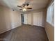 This bedroom provides neutral-toned walls, plush carpet, a ceiling fan, and large closets for storage at 113 W Bluefield Ave, Phoenix, AZ 85023