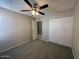 This carpeted bedroom features a ceiling fan and a closet with white doors at 113 W Bluefield Ave, Phoenix, AZ 85023