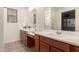 Bright bathroom featuring double sinks, wood cabinets, a large mirror, and a walk-in shower at 11674 E Yeager Cyn, Gold Canyon, AZ 85118