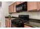 Close-up of the kitchen with black appliances, a gas range, and wood cabinets at 11674 E Yeager Cyn, Gold Canyon, AZ 85118