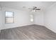 Bright bedroom with laminate flooring, a ceiling fan, and two windows allowing natural light at 12888 N B St, El Mirage, AZ 85335