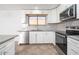 Bright kitchen with stainless steel appliances, white cabinets and light grey backsplash at 12888 N B St, El Mirage, AZ 85335