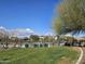 View of a fenced community pool with lawn and distant homes offering resort-style living at 13145 W Whisper Rock Trl, Peoria, AZ 85383