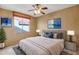 Bedroom with a queen bed, ceiling fan, and a view of the front yard at 15109 W Camino Estrella Dr, Surprise, AZ 85374