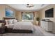Bright bedroom with a king-size bed, large window, and a mounted television at 15109 W Camino Estrella Dr, Surprise, AZ 85374