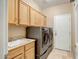 Well-equipped laundry room with ample cabinet space, modern washer, and a sink at 15109 W Camino Estrella Dr, Surprise, AZ 85374