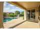 Covered patio overlooking the pool and landscaped backyard with mature trees at 15109 W Camino Estrella Dr, Surprise, AZ 85374