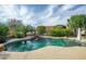 Backyard swimming pool featuring a waterfall and lush landscaping at 15109 W Camino Estrella Dr, Surprise, AZ 85374