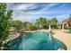 Beautiful backyard pool with rock waterfall feature and lush landscaping in a private setting at 15109 W Camino Estrella Dr, Surprise, AZ 85374