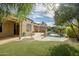 Backyard with a sparkling swimming pool, lush green turf, and landscaped surroundings at 15109 W Camino Estrella Dr, Surprise, AZ 85374