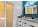 Modern bathroom with turquoise accent wall, white cabinets, granite countertop, and sliding glass shower doors at 16414 N Dixie Mine Trl, Fountain Hills, AZ 85268