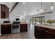 Modern kitchen featuring stainless steel appliances, granite countertops, and dark wood cabinets at 16414 N Dixie Mine Trl, Fountain Hills, AZ 85268