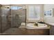 Relaxing bathroom with soaking tub and separate glass-enclosed shower at 16949 W La Reata Ave, Goodyear, AZ 85395