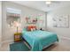 Bright bedroom with a teal bedspread, light walls, neutral tile floor, and a ceiling fan at 16949 W La Reata Ave, Goodyear, AZ 85395