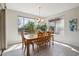 Sunlit dining room with wood table, chairs, and large windows offering a backyard view at 16949 W La Reata Ave, Goodyear, AZ 85395