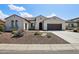 Charming single-story home featuring a desert landscape and a two-car garage with beautiful blue sky at 16949 W La Reata Ave, Goodyear, AZ 85395
