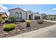Attractive single-story home with desert landscaping including rocks, cacti, and palm trees at 16949 W La Reata Ave, Goodyear, AZ 85395