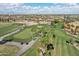 Overhead image showcasing an impeccably maintained golf course with palm trees, manicured lawns, and golf carts in motion at 16949 W La Reata Ave, Goodyear, AZ 85395