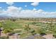 Scenic aerial view of a lush golf course with manicured greens and fairways, set against a bright blue sky with puffy white clouds at 16949 W La Reata Ave, Goodyear, AZ 85395