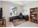 Bright home office featuring a large window, a ceiling fan, and a beautiful wooden bookcase at 16949 W La Reata Ave, Goodyear, AZ 85395