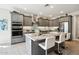 Stylish kitchen with granite island and stainless steel appliances, with white tiling and recessed lighting at 16949 W La Reata Ave, Goodyear, AZ 85395
