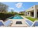 Backyard pool with fire pit, tanning chairs and covered patio at 16949 W La Reata Ave, Goodyear, AZ 85395