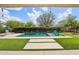 Backyard swimming pool with lush landscaping, lounge chairs, and clear blue sky at 16949 W La Reata Ave, Goodyear, AZ 85395
