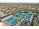 Expansive aerial view of community tennis courts near a picturesque golf course at 16949 W La Reata Ave, Goodyear, AZ 85395