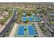 Aerial view of multiple tennis courts with blue surfaces, set against a residential backdrop at 16949 W La Reata Ave, Goodyear, AZ 85395