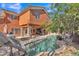 Lush backyard featuring a pool, slide, outdoor kitchen, and covered patio, perfect for outdoor living and entertaining at 20709 N 59Th Dr, Glendale, AZ 85308