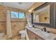 Elegant bathroom with marble countertops, double sinks, decorative mirror, and tiled walls at 20709 N 59Th Dr, Glendale, AZ 85308