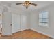 Bedroom featuring wood floors, ceiling fan, window with blinds, and closet with sliding doors at 20709 N 59Th Dr, Glendale, AZ 85308