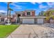 Inviting two-story home showcasing a spacious driveway, three car garage, stone accents and lush green lawn at 20709 N 59Th Dr, Glendale, AZ 85308