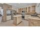 Well-lit kitchen with stainless appliances, center island, custom cabinetry, and granite countertops at 20709 N 59Th Dr, Glendale, AZ 85308
