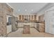 Bright kitchen featuring stainless steel appliances, tile floors, island with stone base, and custom cabinets at 20709 N 59Th Dr, Glendale, AZ 85308
