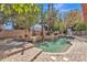 Lush backyard oasis with a sparkling pool, spa, and charming fountain surrounded by mature trees and landscaping at 20709 N 59Th Dr, Glendale, AZ 85308