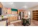 Well lit kitchen features wooden cabinets, stainless steel appliances, tiled counters, and a small island at 226 N 96Th St, Mesa, AZ 85207