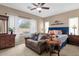 Comfortable bedroom featuring a cozy sofa, a ceiling fan and plenty of natural light at 2514 E Espada Trl, Casa Grande, AZ 85194