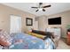 Bright bedroom offering a dresser, mounted TV, and a ceiling fan for ultimate relaxation at 2514 E Espada Trl, Casa Grande, AZ 85194