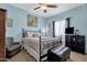 Serene bedroom with blue walls, carpeted flooring, ceiling fan, and comfortable furnishings at 2514 E Espada Trl, Casa Grande, AZ 85194