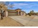 Attractive home with a long driveway, two-car garage, desert landscaping, and stone entryway at 2514 E Espada Trl, Casa Grande, AZ 85194