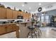 Open kitchen with raised breakfast bar seating, wood cabinets, and modern appliances at 2514 E Espada Trl, Casa Grande, AZ 85194