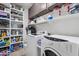 Convenient laundry room with washer, dryer, shelving, and ample storage space at 2514 E Espada Trl, Casa Grande, AZ 85194