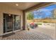 A covered patio with brick pavers, comfortable seating, and an outdoor fire pit creating a relaxing backyard retreat at 2514 E Espada Trl, Casa Grande, AZ 85194