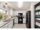 Bright kitchen featuring granite countertops, white cabinetry, and a black appliance package at 3236 E Tanglewood Dr, Phoenix, AZ 85048