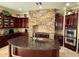 Spacious kitchen featuring a large island, brick accent wall, stainless steel appliances, and custom cabinetry at 3410 E Vallejo Ct, Gilbert, AZ 85298