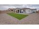 Large backyard featuring a covered patio, artificial grass, and gravel landscaping at 40520 W Haley Dr, Maricopa, AZ 85138