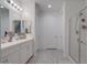 Well-lit bathroom with double vanity, white cabinetry, and a glass-enclosed shower at 40520 W Haley Dr, Maricopa, AZ 85138