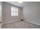 Bright, carpeted bedroom with white trim, shutters, and a cozy chair at 40520 W Haley Dr, Maricopa, AZ 85138